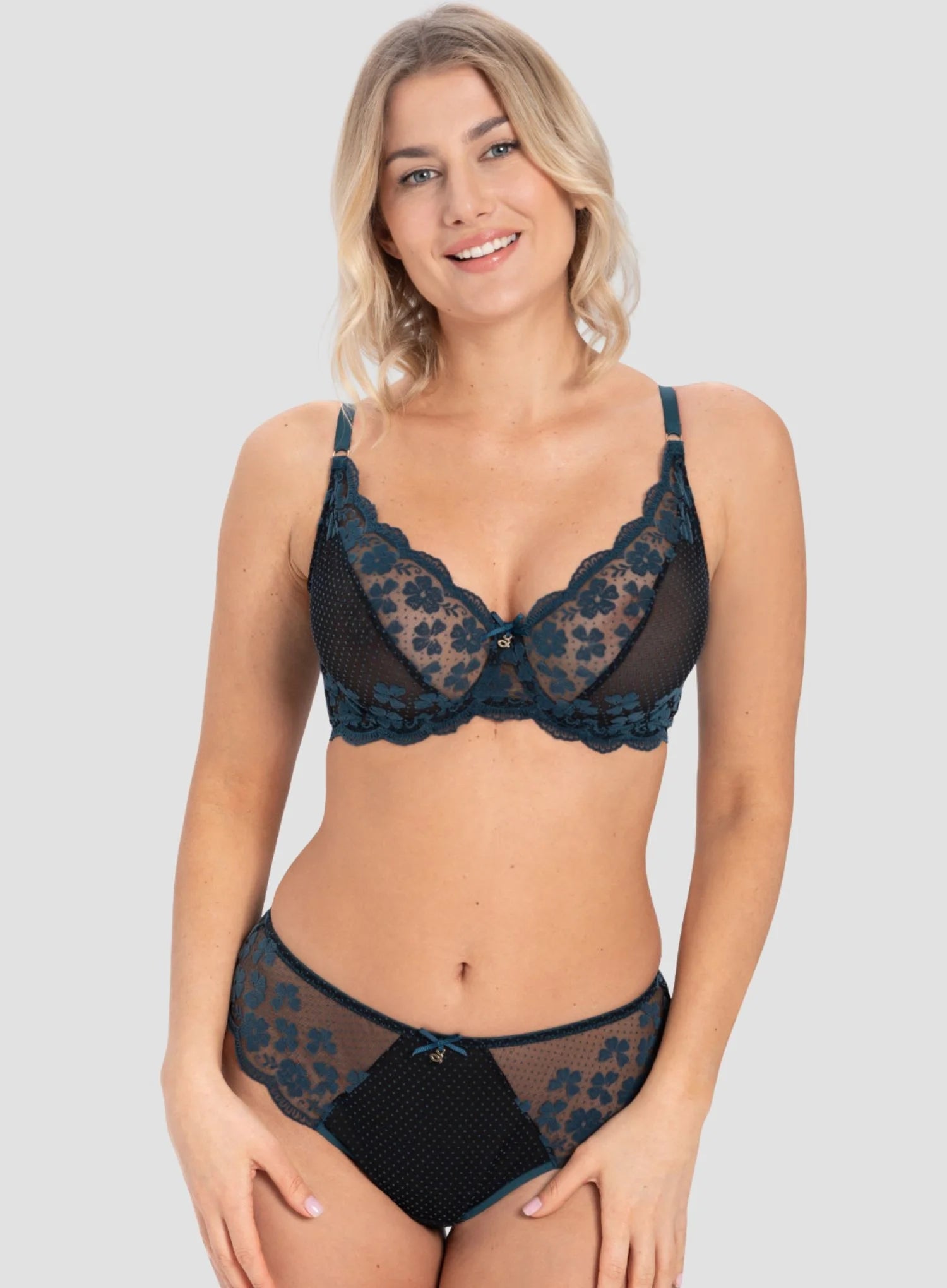 Woman wearing a black lace lingerie set on a plain background