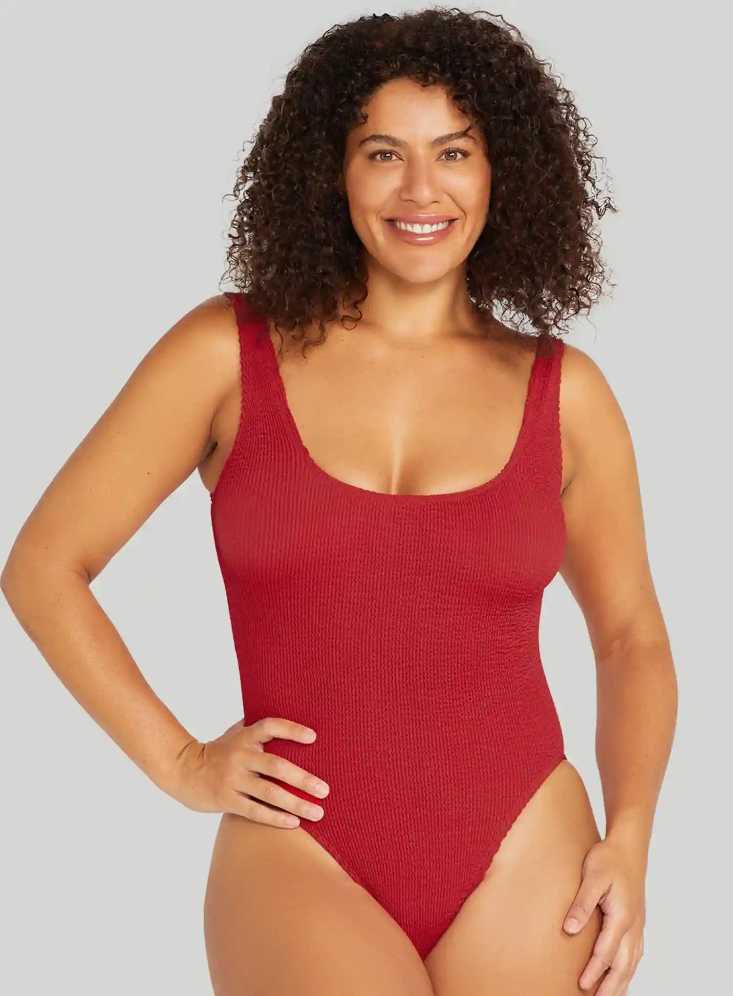 Woman wearing a red swimsuit against a gray background