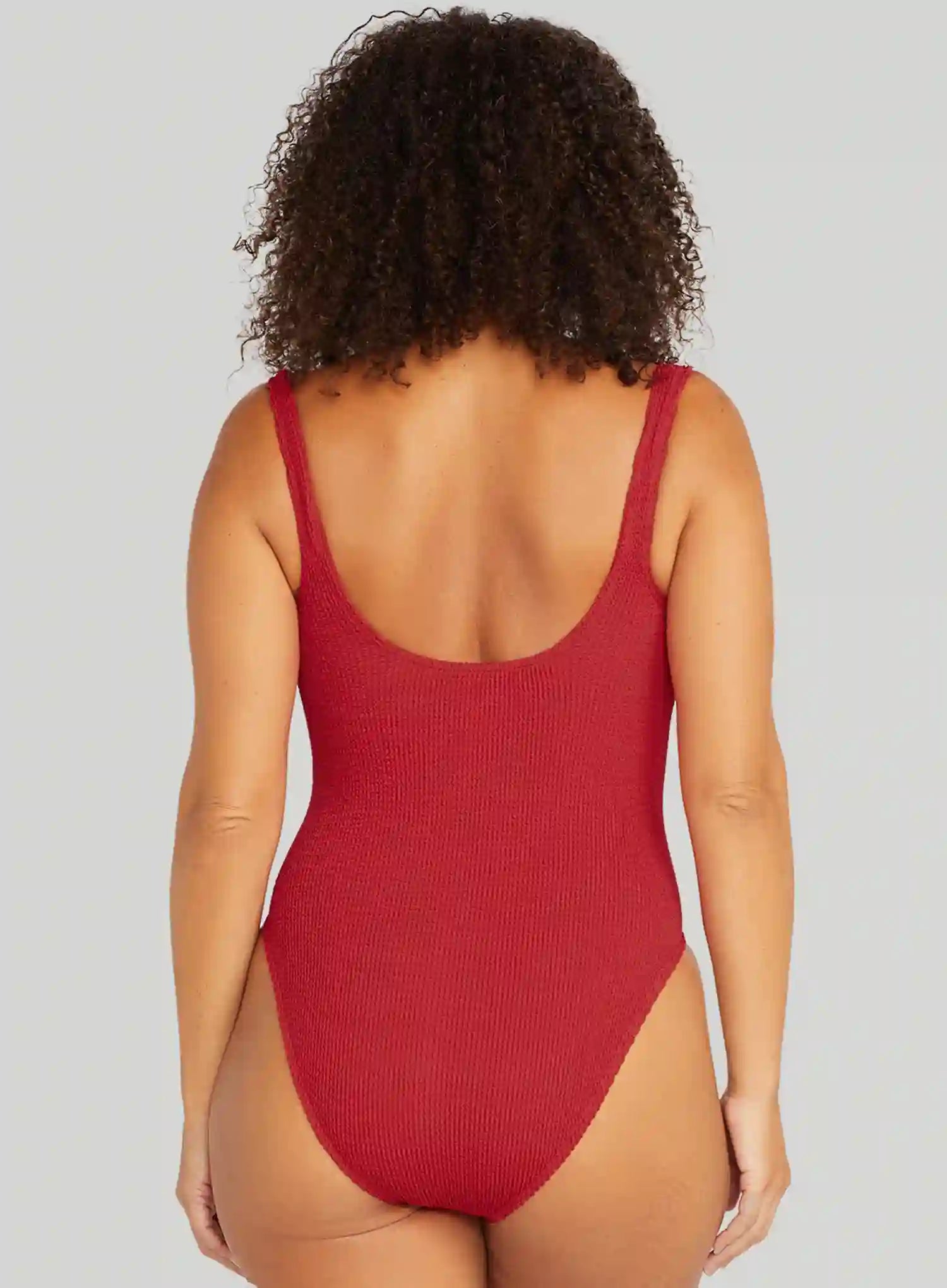 Red swimsuit worn by a person on a plain background
