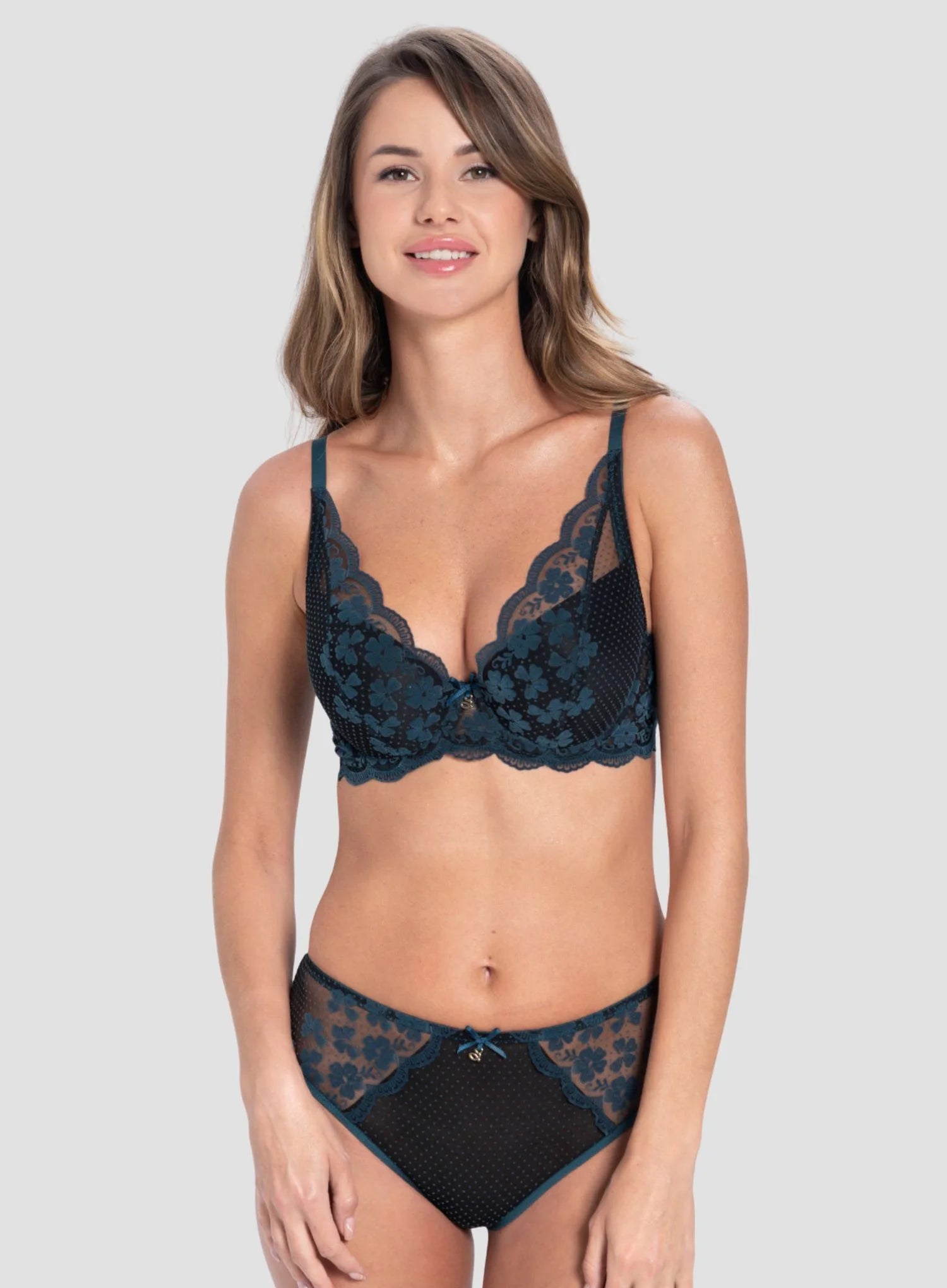 Woman wearing a black lace lingerie set on a plain background