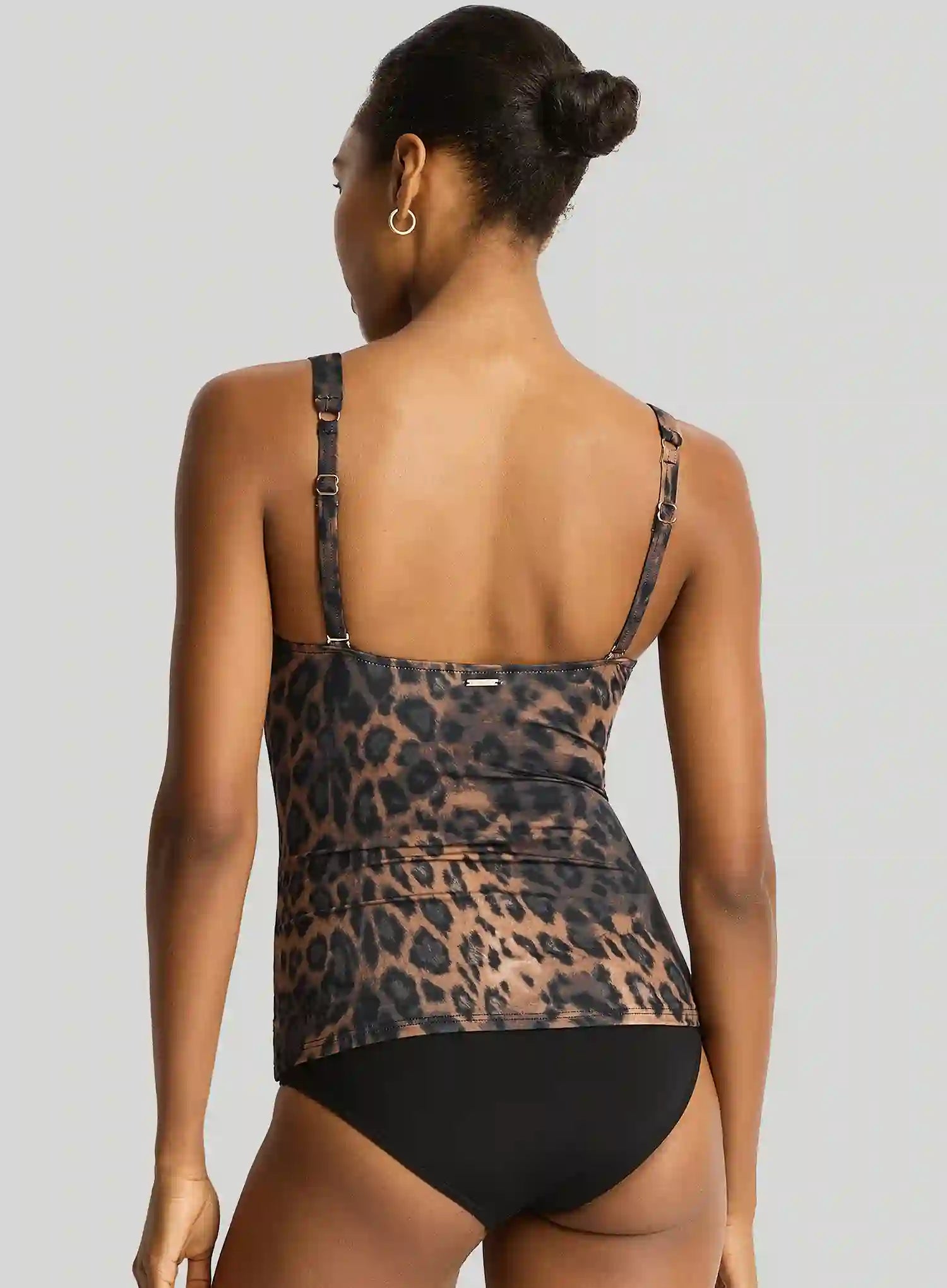 Person wearing a leopard print swimsuit on a plain background