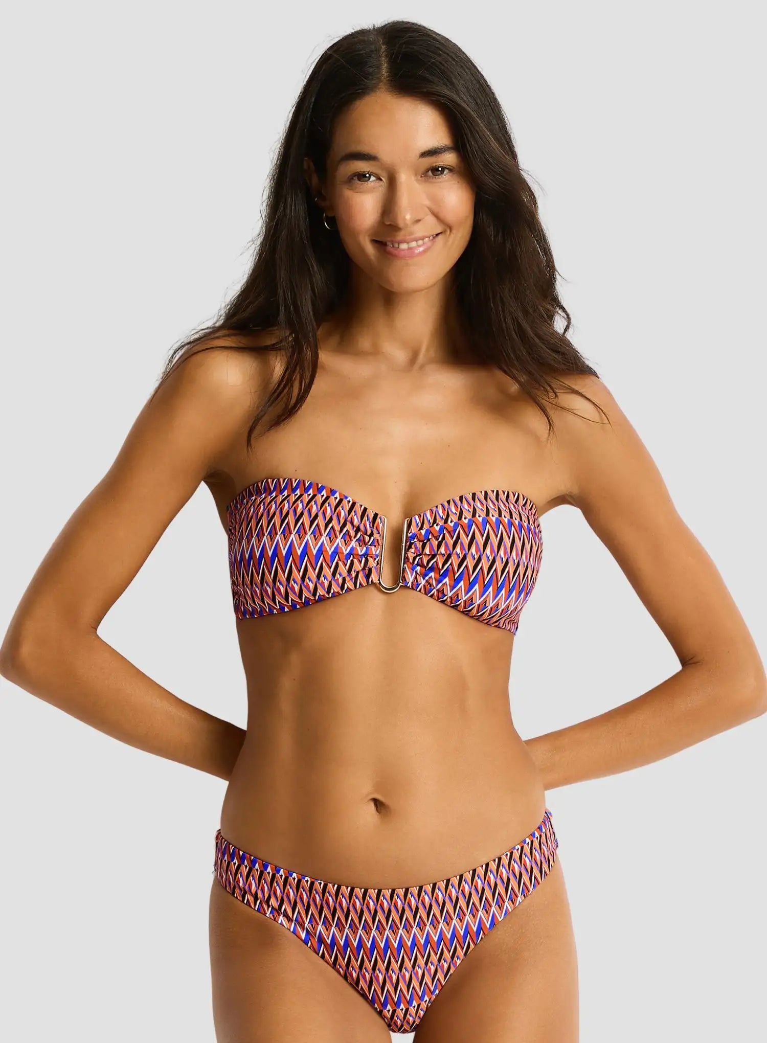 Woman wearing a colorful bikini set against a plain background