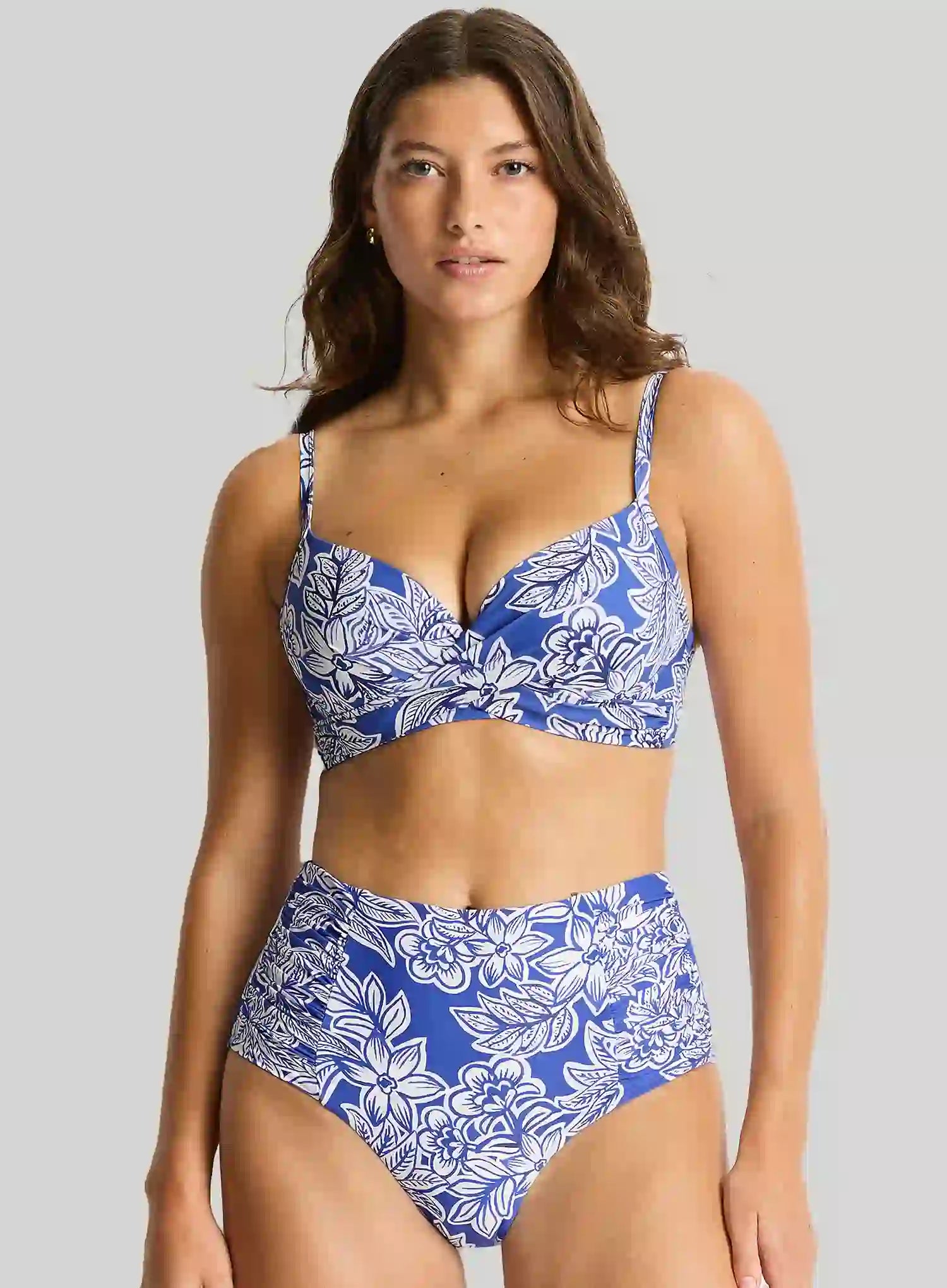 Woman wearing a blue and white floral bikini against a gray background