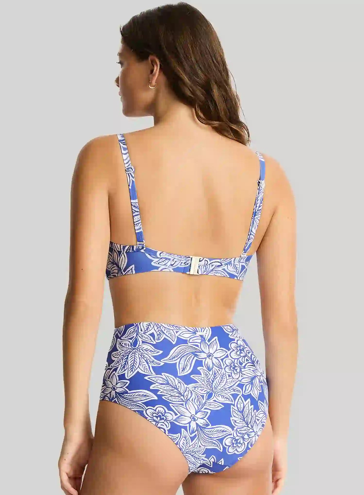 Woman wearing a blue and white floral bikini against a gray background