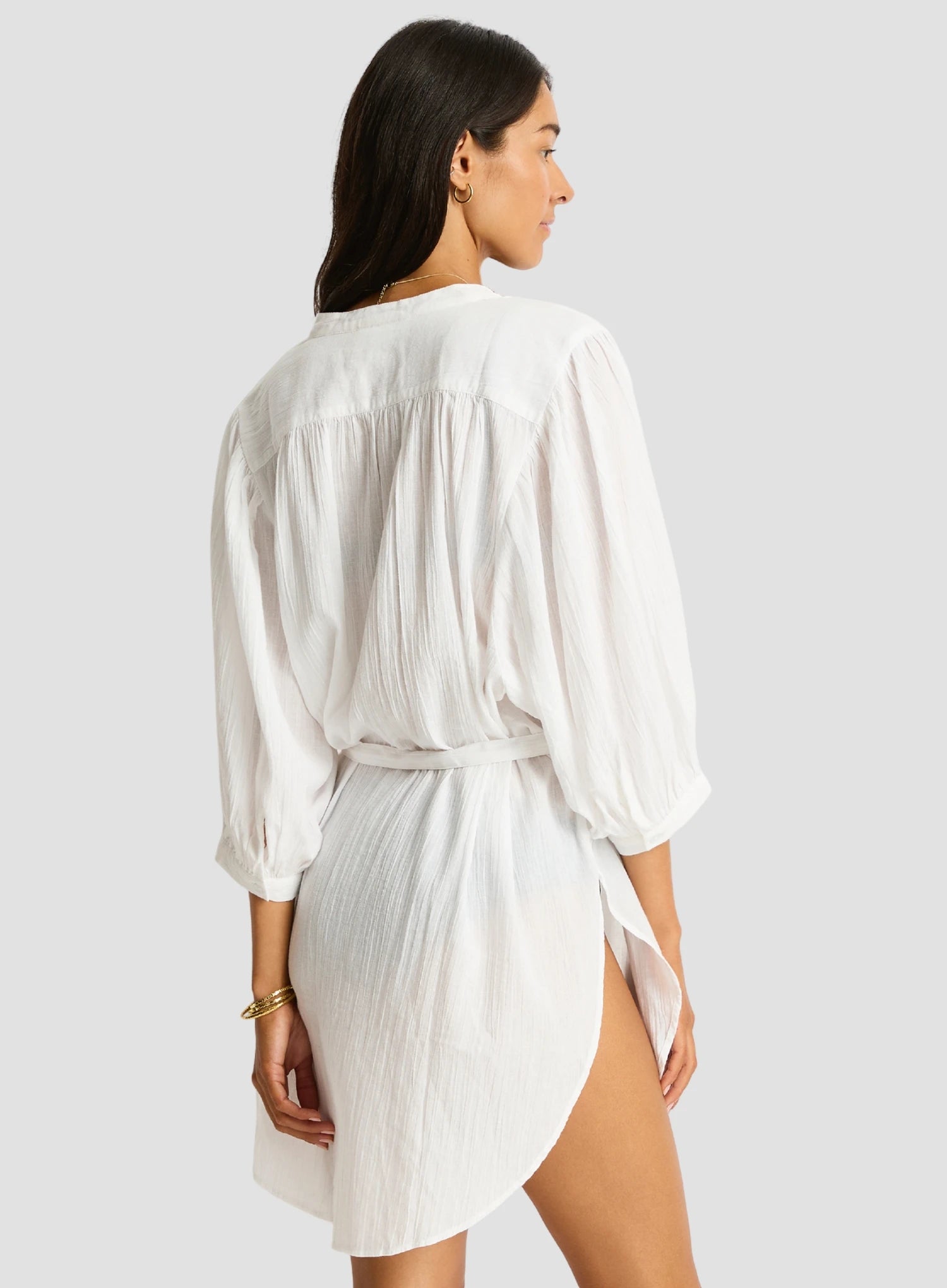 Woman wearing a white dress with a plain background